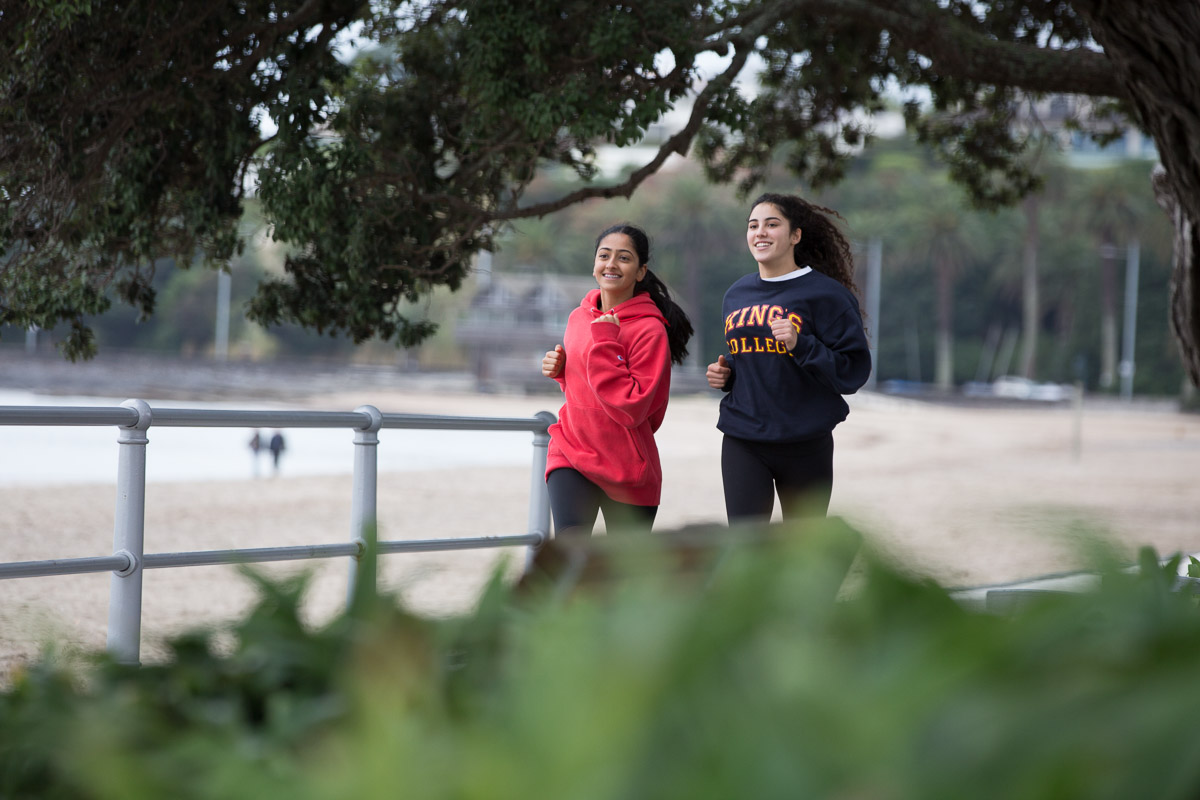 Two King's College girls run along the waterfront at Kohimarama